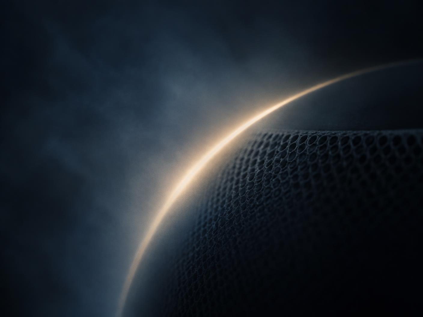A curve of warm light across a dark acoustic surface